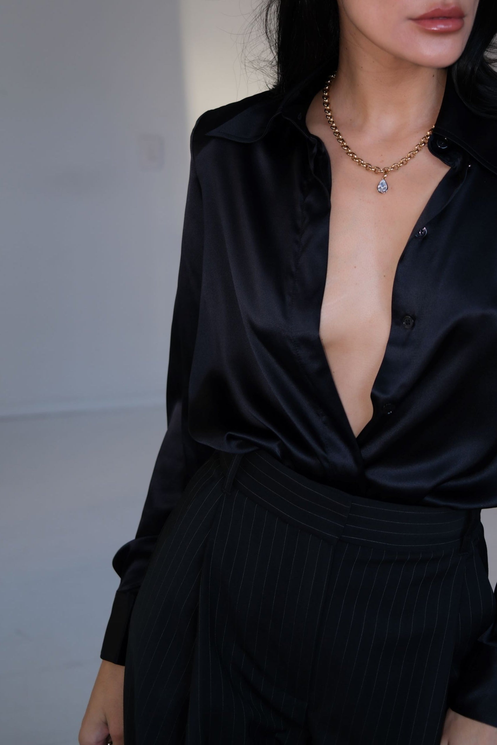 woman wearing black with gold belcher chain and pear pendant set in rhodium plating with gold